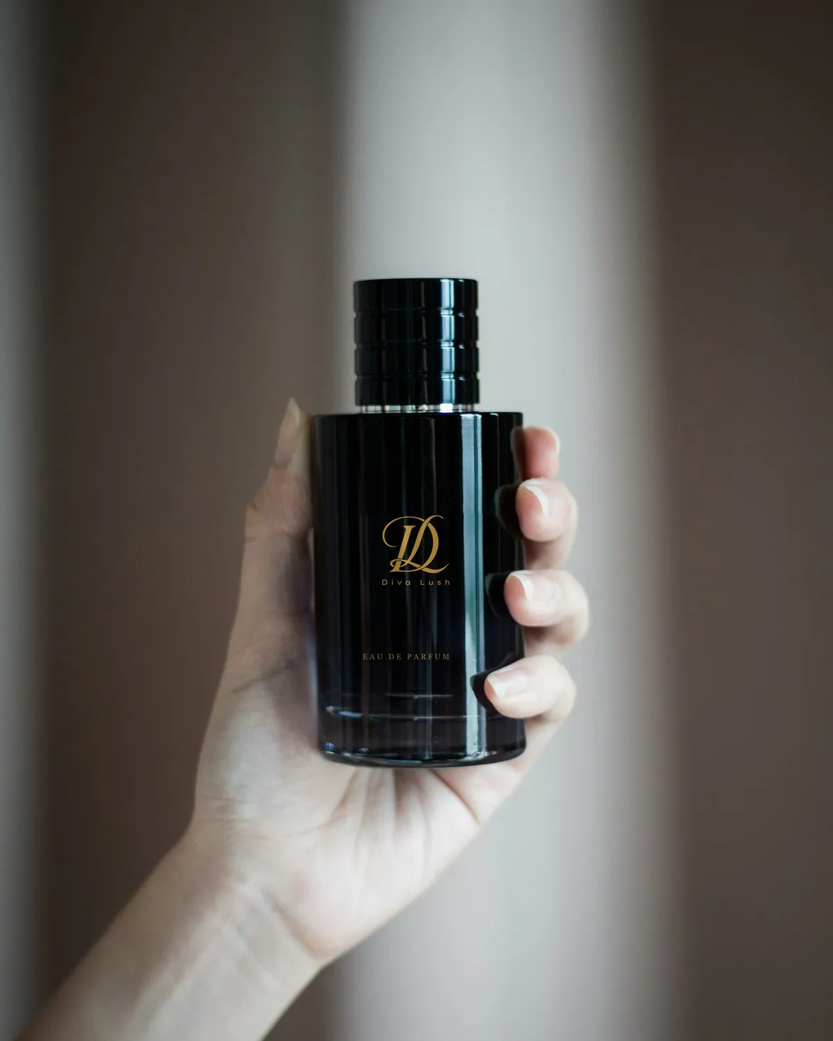 Black Diva Lush perfume bottle held in a hand