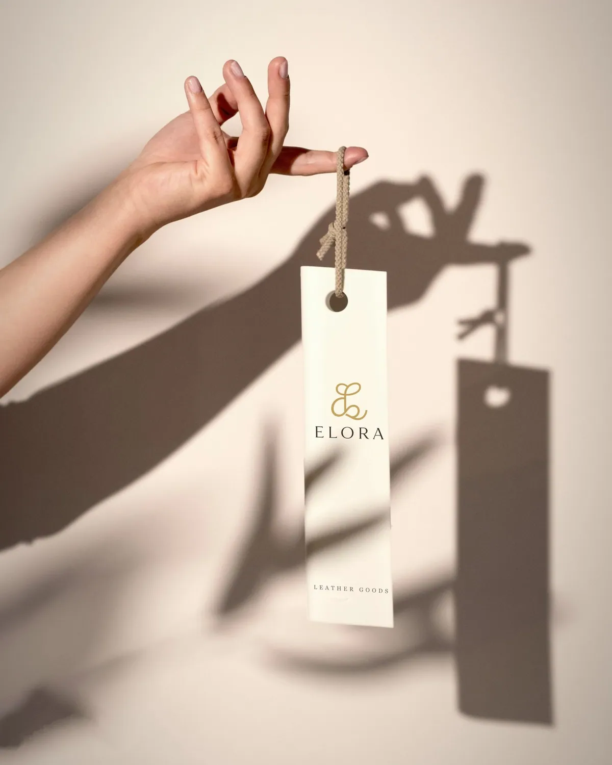 Elora swing tag held up against a sunlit wall