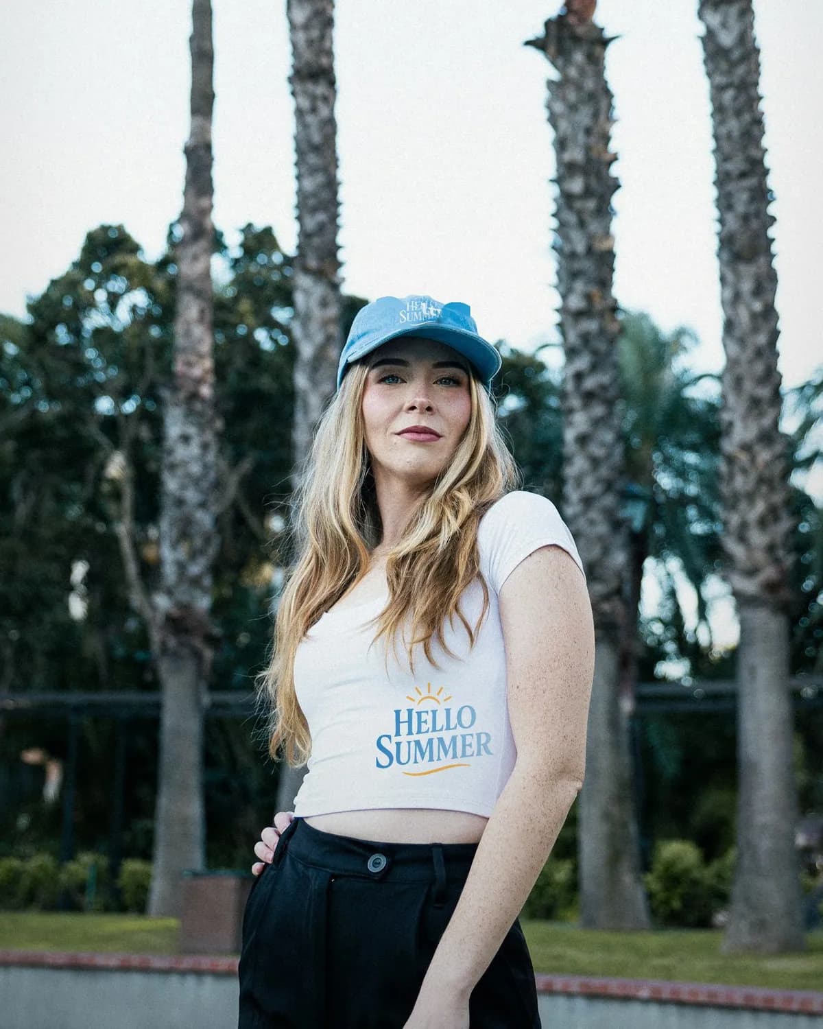 Hello Summer on a blue cap and a white top, among palm trees
