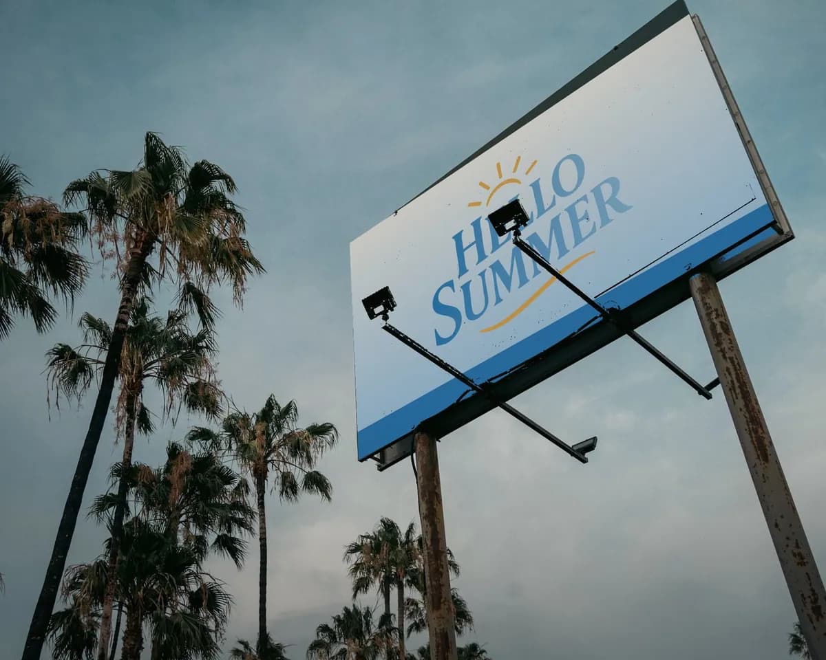 Hello Summer roadside sign above palm trees