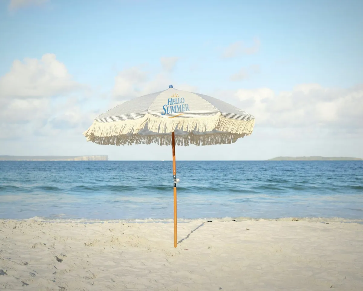 Hello Summer printed on a fringed beach umbrella
